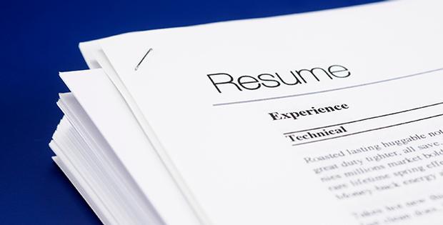 stack of white colored resumes on a blue background