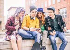 four teenagers hanging out playing video games